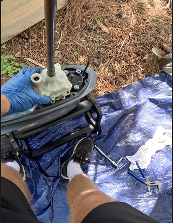 Water pump housing being reinstalled over an outboard impeller during annual service