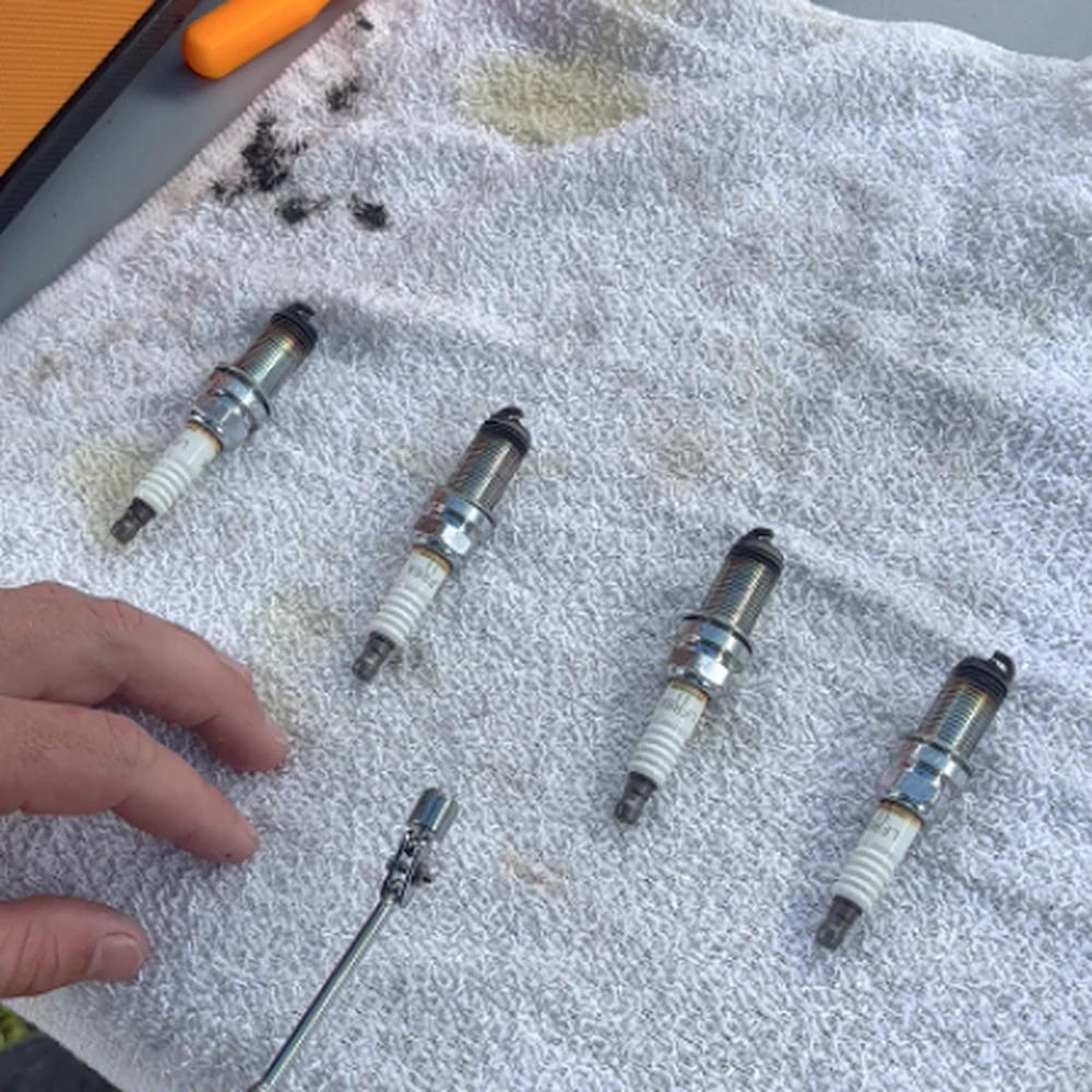 Spark plugs checked during routine outboard maintenance